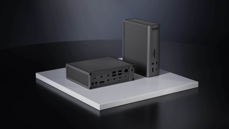 CalDigit TS5 Plus dock stende ved siden af en MacBook i minimalistisk setup med gr baggrund