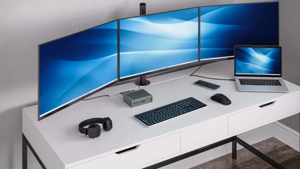 Caldigit TS5 dock i workstation med tre buede skrme og MacBook  velegnet til multitasking og redigering.